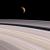 Una falce di Titano si staglia in lontananza sulla sottile struttura degli anelli di Saturno 